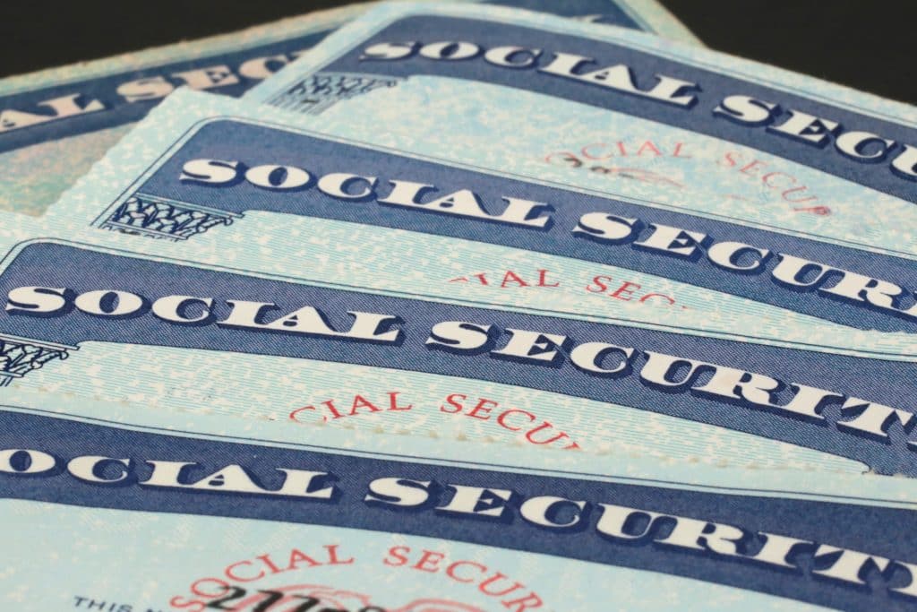 Close-up of five Social Security cards laid out on top of each other.
