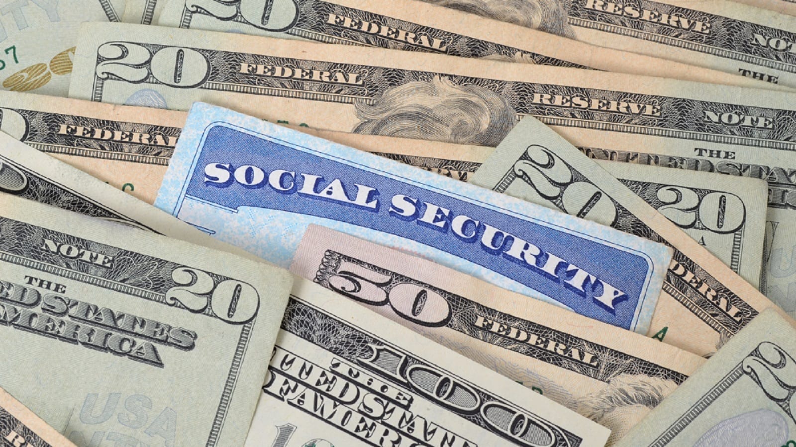 A Social Security card partially tucked between $20, $50, and $100 bills.