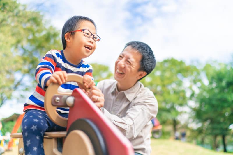 a child with down syndrome playing with his dad at a Los Angeles park