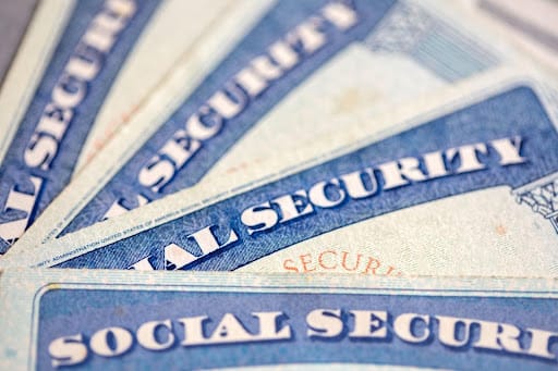 Close-up of four Social Security cards laid out on top of each other.